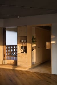 A modern kitchen with natural wood finishes and minimalist design features.