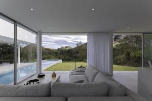 Modern white-painted interior with furniture and a view of a spa pool.
