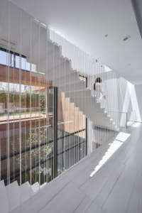 White staircase with glass panels in a modern architectural interior design.