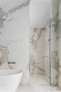 Modern minimalist bathroom featuring marble walls and floor.