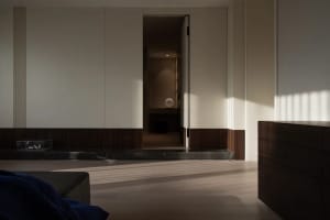 Modern minimalist interior design featuring wooden flooring and marble columns.
