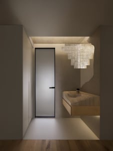 Modern minimalist bathroom with glass elements and a floating sink.