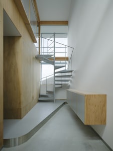 A minimalist interior with a metal staircase and wooden walls.