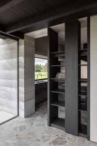 Concrete porch with black columns and a stone floor