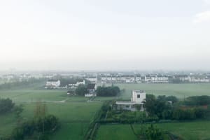 A aerial view of a urban landscape with buildings and green fields.