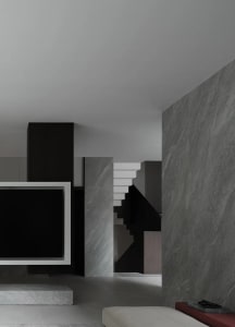 Modern interior design featuring a floating staircase with dark metallic elements in a living room setting.