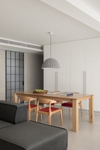 A modern, minimalist residential dining room with a wooden table and chairs.