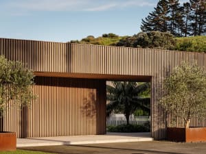 A modern entryway featuring a wooden wall with vertical panels and an overhang.