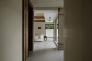 A minimalist living room featuring concrete walls and floor.