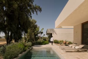 A minimalist residential exterior featuring concrete and glass materials.