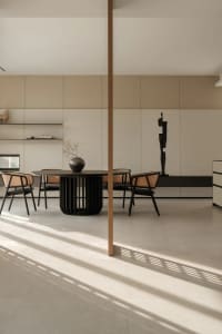 Minimalist dining room with a modern table, chairs, and vases in a contemporary interior design