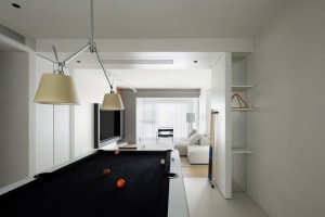 Modern minimalist living room with concrete flooring, metal accents, and sleek furniture.