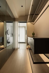 Modern interior with a wooden closet featuring sleek black drawers and a minimalist design.