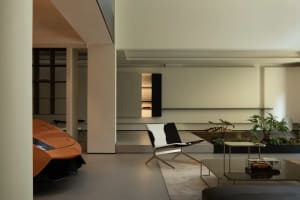 A modern living room featuring concrete and glass elements.