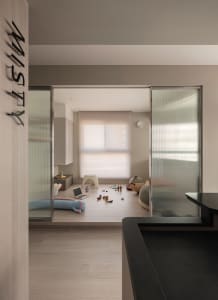 A modern residential playroom featuring wooden flooring, steel furniture, and glass doors.