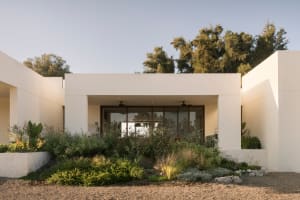 Modern residential exterior with concrete walls and landscaping.
