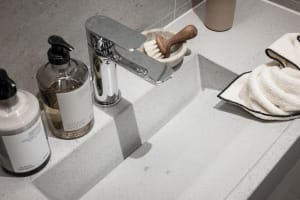 Modern bathroom interior featuring a sleek concrete countertop and minimalist fixtures.