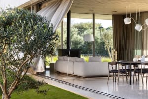 A minimalist living room with metal, glass, and laminate materials.