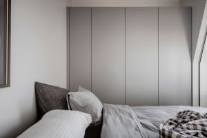A minimalist bedroom with a bed, pillows, and a window.