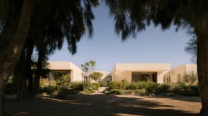 Modern minimalist house with concrete exterior and large windows.