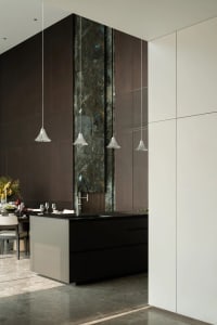 Modern kitchen interior featuring marble countertops, wooden cabinets, and stainless steel appliances