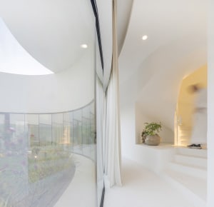 Modern interior space featuring large glass windows and arches.