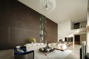 A modern living room with a large wooden wall and a crystal chandelier hanging from the ceiling.