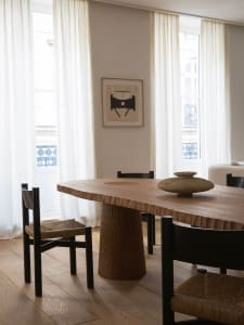 Modern dining room with wooden table and chairs, natural light, and minimalist design.