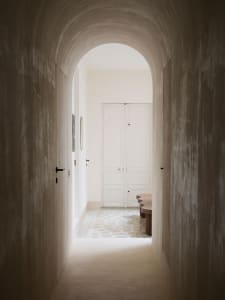 An image of a modern hallway featuring an architectural concrete archway.