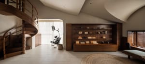 A modern residential library featuring wooden shelves and furniture.