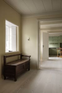 A minimalist interior featuring wood and plaster materials.