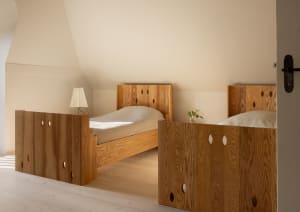 A modern bedroom featuring two wood-paneled beds.