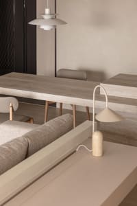 Modern dining room featuring minimalist concrete furniture and sleek, neutral tones.