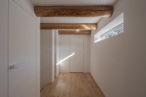A minimalist interior design featuring wooden elements and a natural light source.