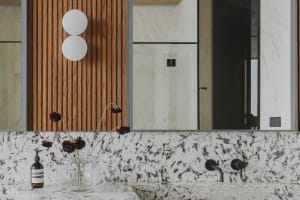 Modern bathroom featuring a luxurious granite countertop with a minimalist sink and sleek metallic faucet, illuminated by a c