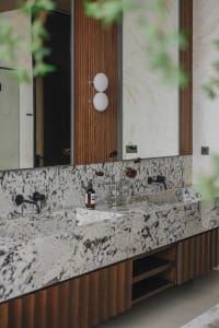 Modern bathroom with granite countertop and wooden cabinets.
