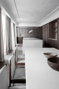 Modern residential kitchen featuring a sleek, minimalist design with a white concrete countertop and wooden elements.