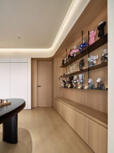 A modern home office with wooden shelves displaying various stuffed animals.