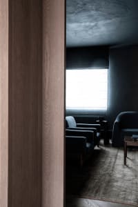 A minimalist interior space featuring wood and concrete finishes.