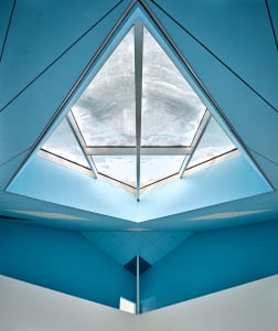 Interior view of a modern office with a glass ceiling showcasing sleek, contemporary design elements.