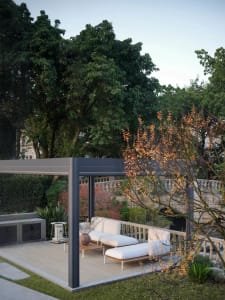 An outdoor living area with modern metal structures and white cushions on a deck.