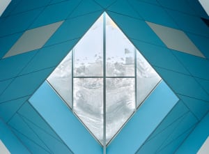 A modern interior design featuring a glass window with a blue geometric pattern.