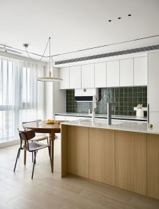 a modern residential kitchen featuring wooden cabinets and glass backsplash.