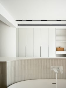 Modern minimalist bathroom design with white ceramic tiles and sleek white fixtures.