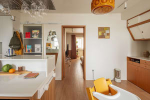 Modern minimalist apartment featuring white wooden flooring, glass panel doors, and metal accents.