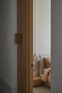 A modern bedroom featuring wooden architectural elements and soft lighting.