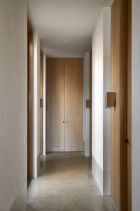 Modern interior design with concrete floor and wooden walls, featuring a minimalist corridor.