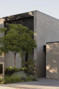 Modern residential home entrance featuring a concrete facade and minimalist design.