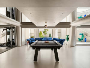 A modern living room with glass walls and metal accents.
