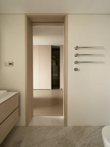 Modern minimalist bathroom with marble flooring and white fixtures.